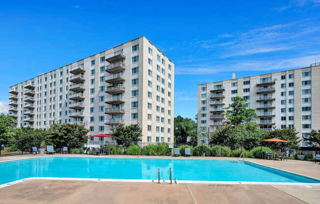 a swimming pool with an apartment building in the background