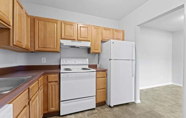 a kitchen with white appliances and wooden cabinets