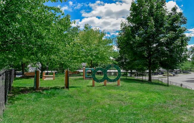 a park with trees and a sculpture in the grass