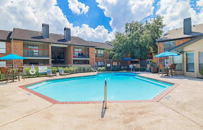 A swimming pool surrounded by a fence and chairs.