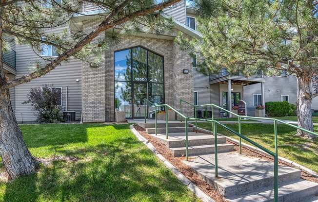 the front of a house with stairs and a tree