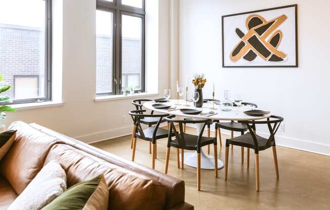 a dining room with a table and chairs and a couch in a 555 waverly unit at The Ferguson Apartments, Detroit, Michigan
