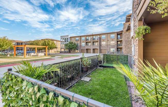 a backyard with a lawn and a fence and an apartment building