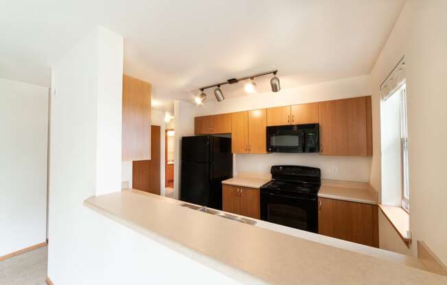 a kitchen with wood cabinets and black appliances