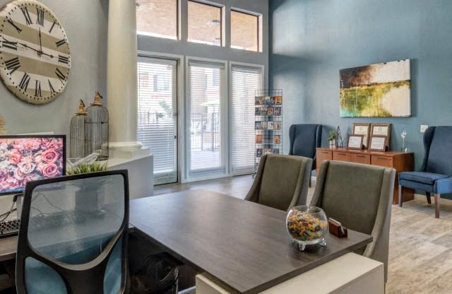 Ingleside Apartments Leasing Office desk with side chairs and blue accent wall