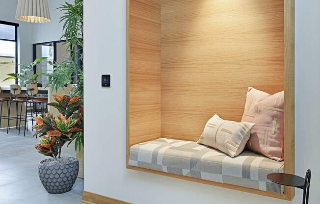 A modern room with a wooden panelled wall and a bench with cushions.