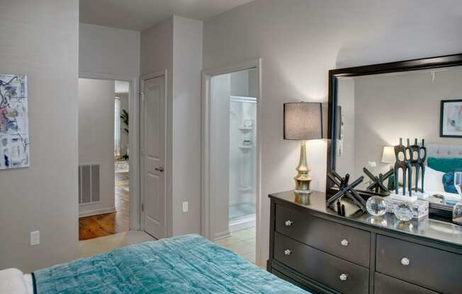 a bedroom with a bed and a dresser with a mirror