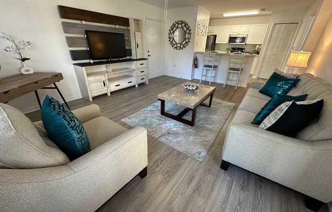 A living room with a couch, a coffee table, and a television.