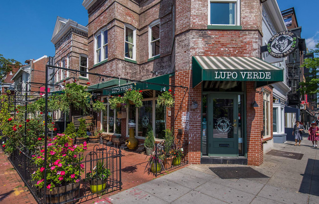 A brick building with a green awning that says
