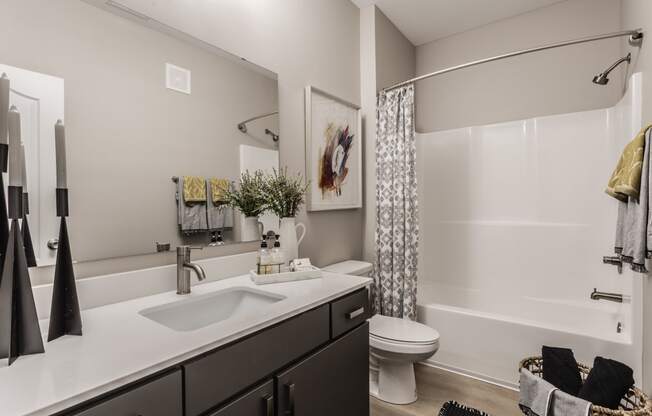 an open bathroom with a shower sink and toilet