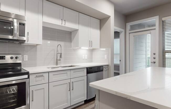 a kitchen with white cabinets and a white counter top