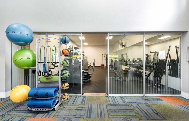 a gym with weights and cardio equipment and glass doors