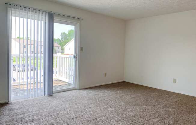 Spacious living room with balcony at Waterstone Place Apartments in Indianapolis, IN 46229