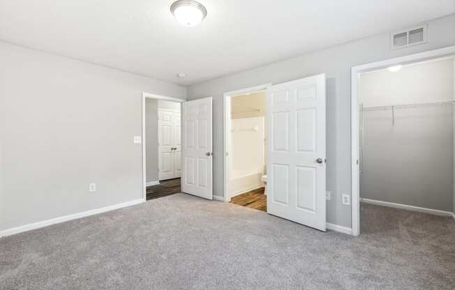an empty living room with white doors and a door to a closet