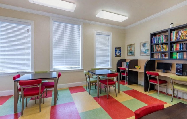 Activity Center with color floor mats, shelves, with books, and computers