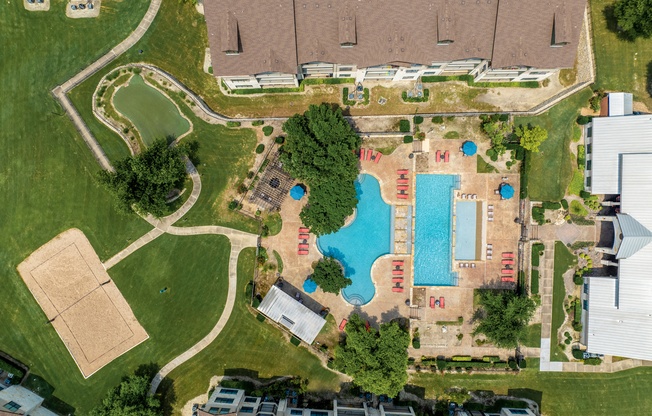 arial view of a swimming pool in a residential neighborhood with houses and trees