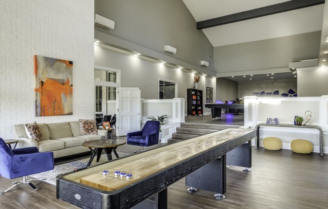 Community clubhouse with a shuffleboard table and lounge seating