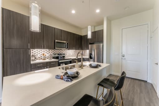 a renovated kitchen with white cabinets and a stainless steel refrigerator at Residences at 3000 Bardin Road, Texas