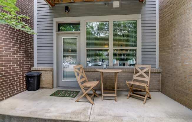 Apartment unit patio with two chairs and a table