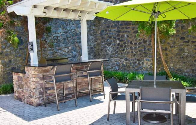 a patio with a bar and tables with umbrellas