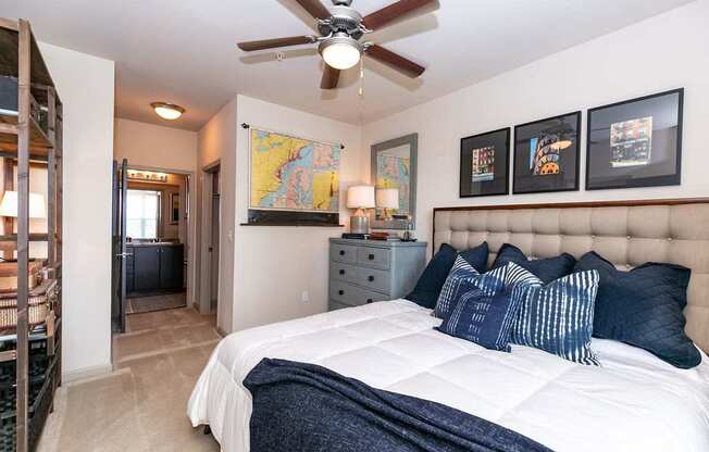 A bedroom with a large bed and a ceiling fan.