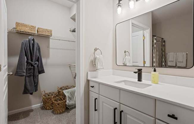 Flatiron West Trade Apartments staged model unit bathroom with a quartz countertop and attached walk-in closet