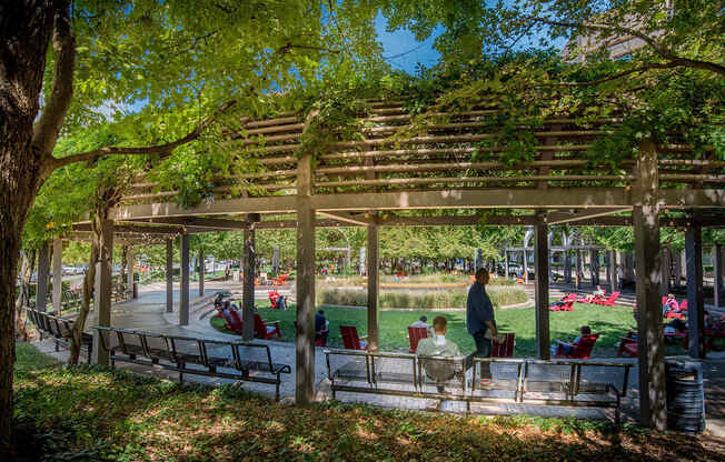 a group of people sitting on benches in a park at The Acadia at Metropolitan Park, Virginia