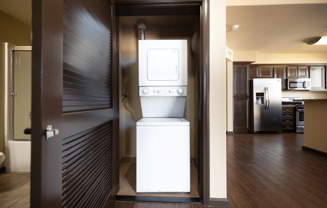 A white oven is in a kitchen with a dark brown door.