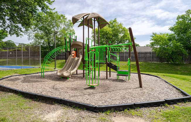 a playground with a swing set and slides in a park