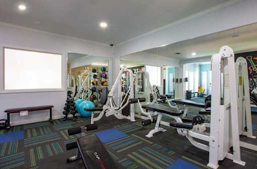 A gym with a variety of equipment including weights and machines.