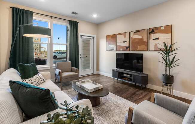 a living room with a couch and chairs and a television