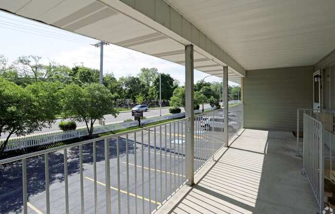 the view from the porch of a building with white metal railings