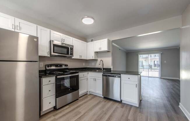 A kitchen with stainless steel appliances and white cabinets.