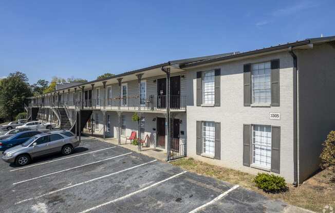 an apartment building with cars parked in a parking lot