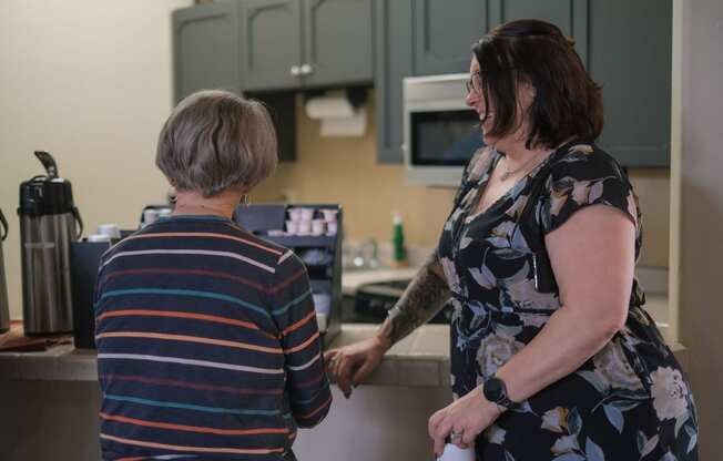 two women in a kitchen talking to each other