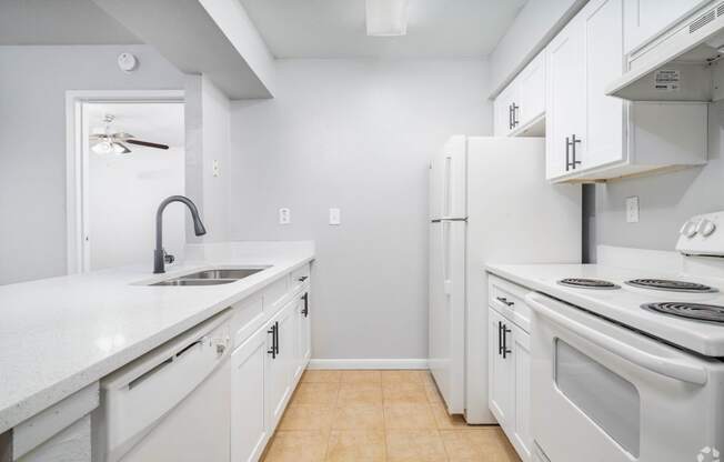 a white kitchen with white appliances and white cabinets