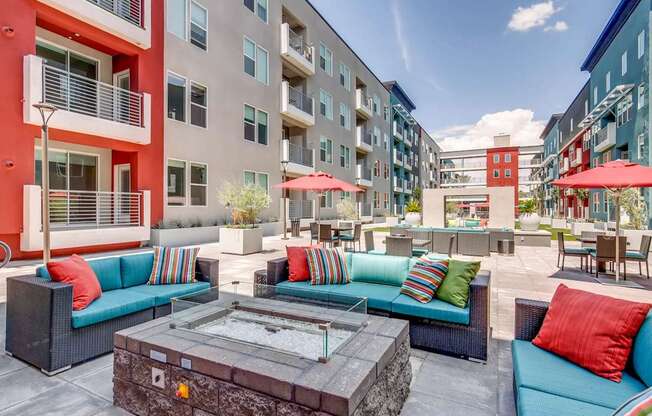 A patio with a table and chairs is surrounded by apartment buildings.
