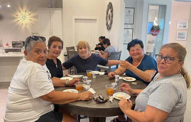 A group of people are sitting around a table eating food.