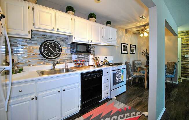 a kitchen with white cabinets and a clock on the wall at Village Club of Rochester Hills, Shelby Township, MI 48317