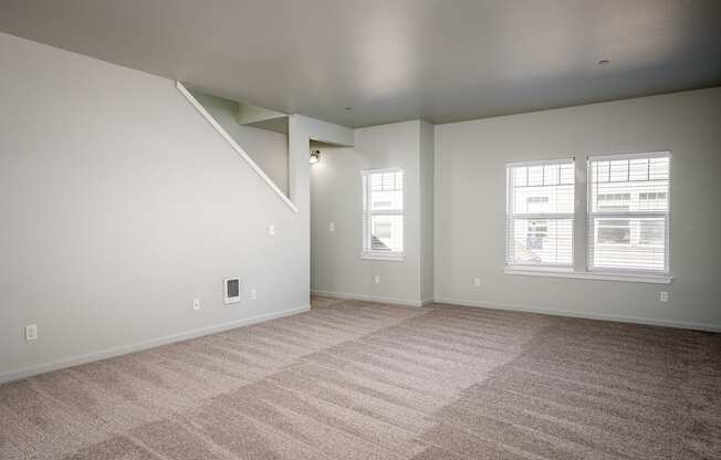 A room with a carpeted floor and a window.