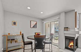 a living room with a fireplace and a table and chairs