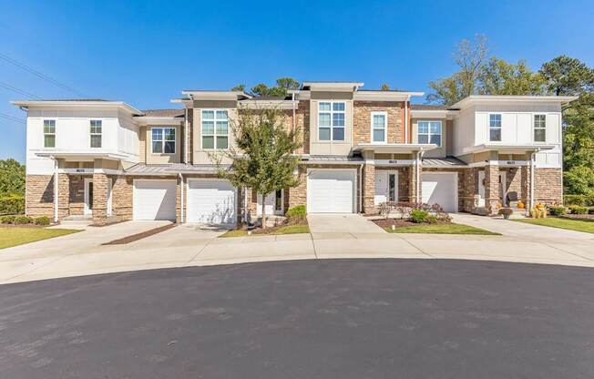 A large, modern house with a driveway in front.