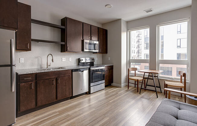 a kitchen with dark wood cabinets and stainless steel appliances