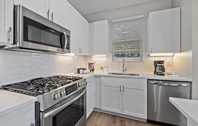 a kitchen with white cabinets and stainless steel appliances