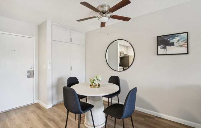 a dining room with a table and chairs and a ceiling fan