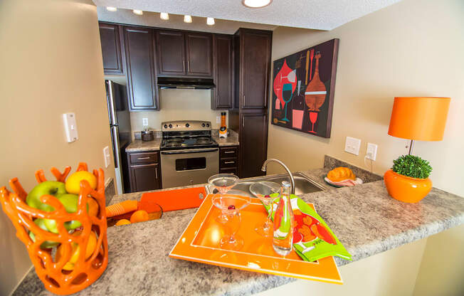 A kitchen with a counter top and a fruit basket.