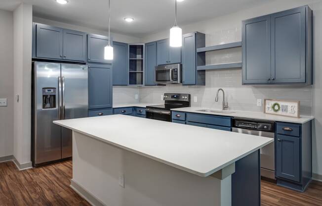 a kitchen with blue cabinets and a white island