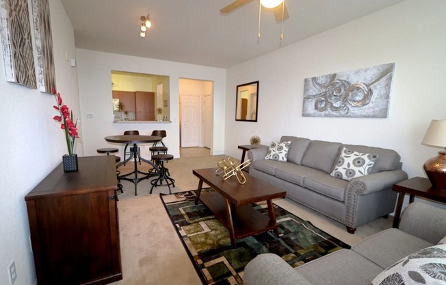 A living room with a grey couch and a wooden coffee table.