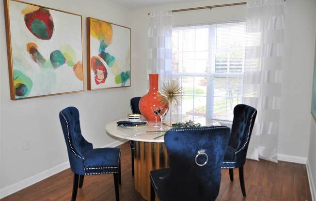 A dining room with a white table and blue chairs.