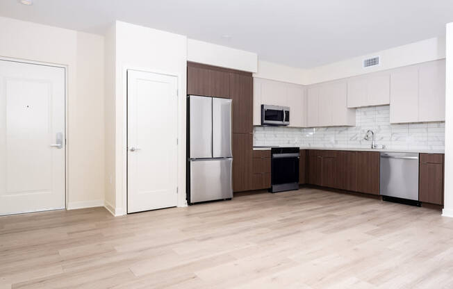 A kitchen with white cabinets and a wooden floor.